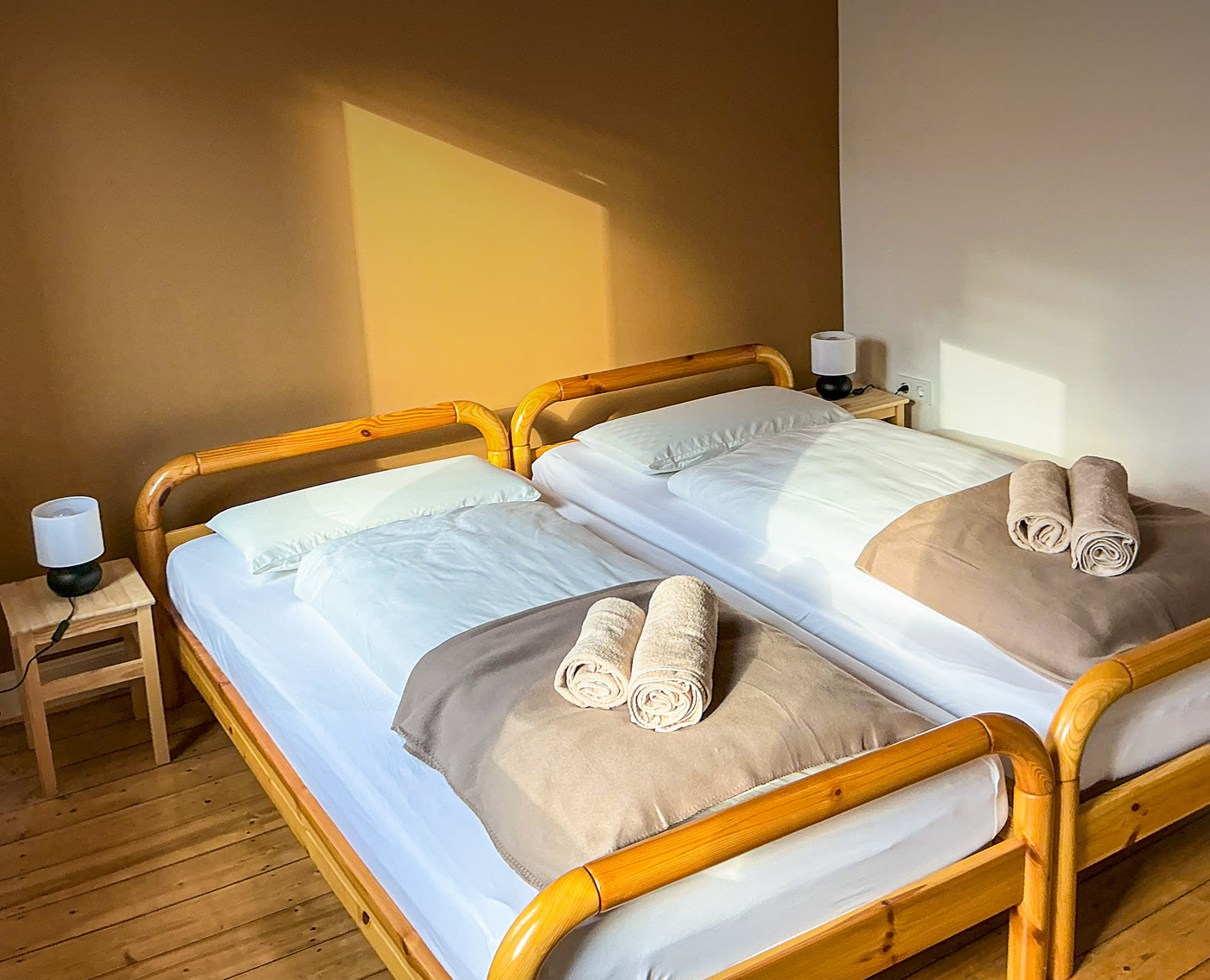 Frisch bezogene Betten mit gefalteten Handtüchern in einer Ferienwohnung