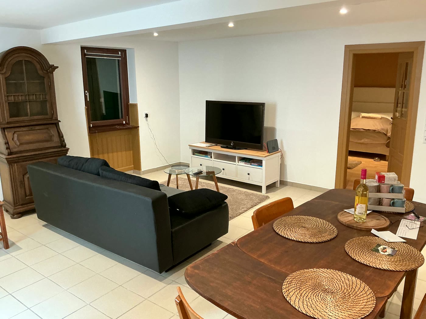Helles, aufgeräumtes Wohnzimmer mit Sofa und Esstisch