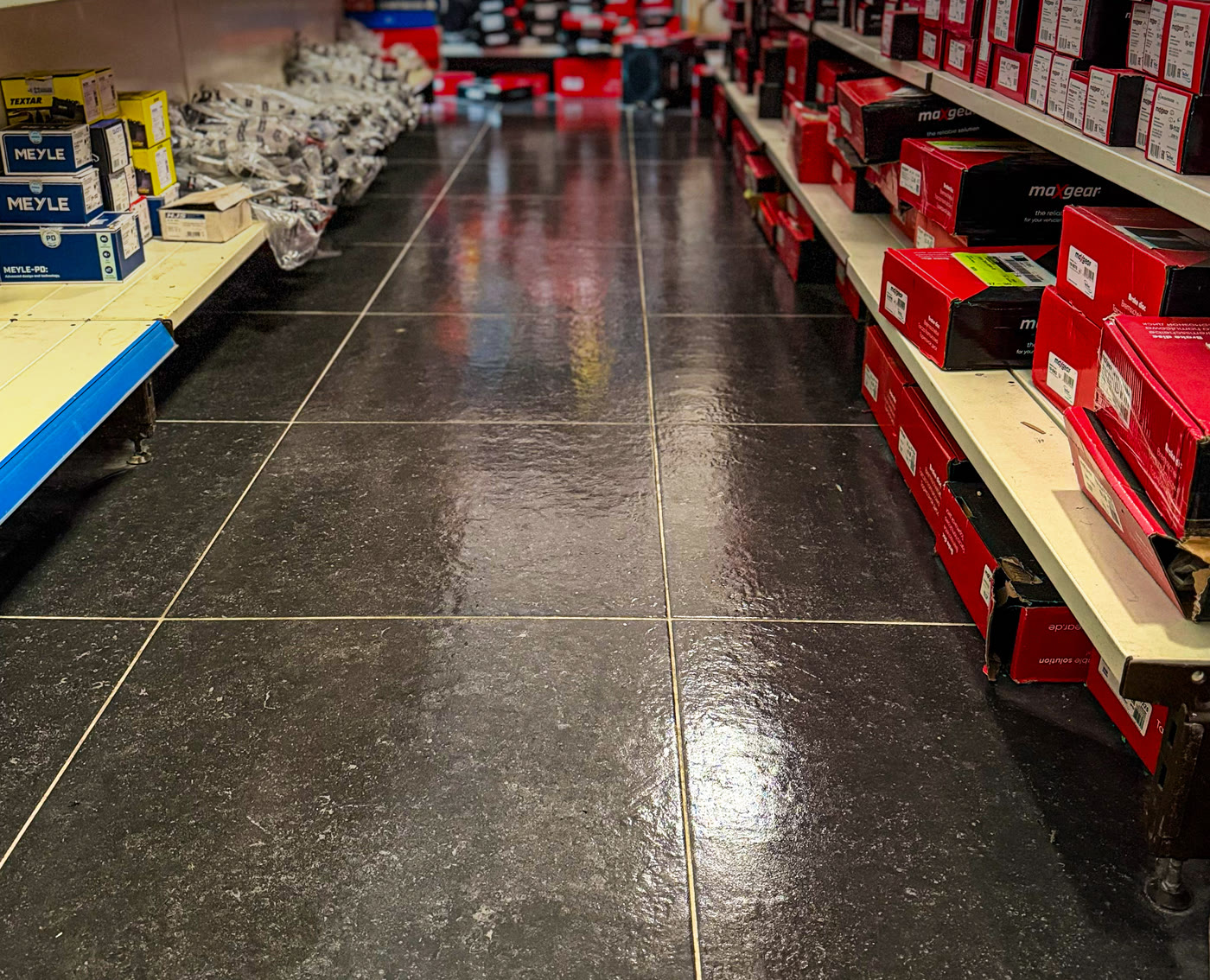 Gereinigter Fliesenboden zwischen Regalen